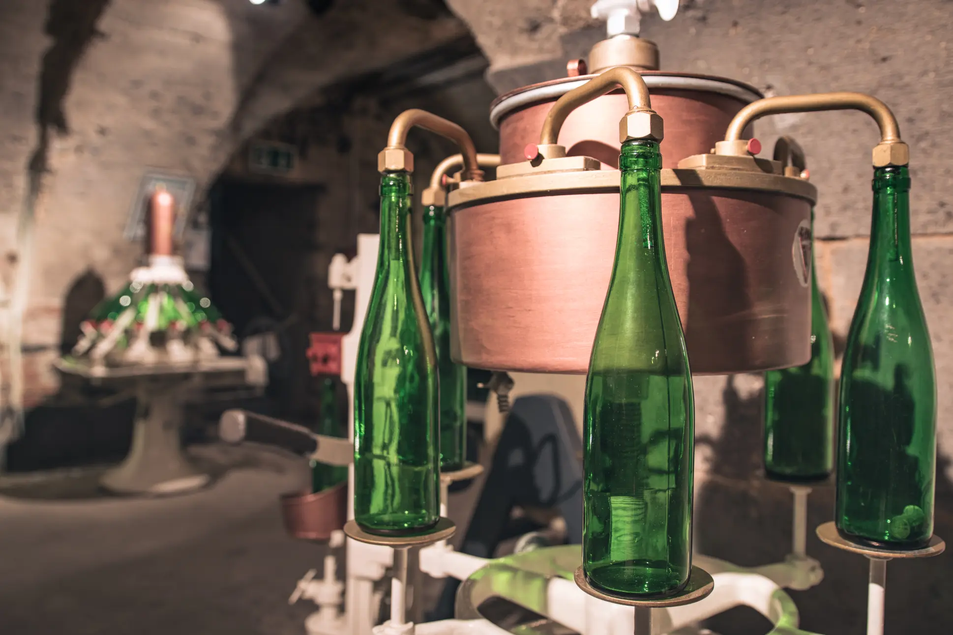 Detailaufnahme von grünen Sektflaschen in einer Reinigungsmaschine im Sektmuseum Koblenz.